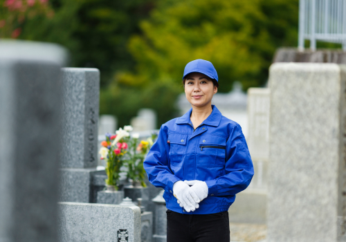 お墓に立っている女性スタッフ
